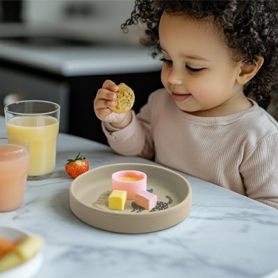 Assiette bebe gris devant son assiette