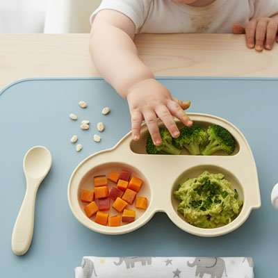 Assiette bébé ventouse beige avec la main de bébé